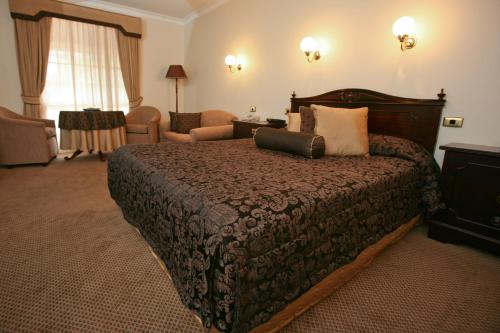 a hotel room with a large bed and a chair at Australian Heritage Motor Inn in Dubbo