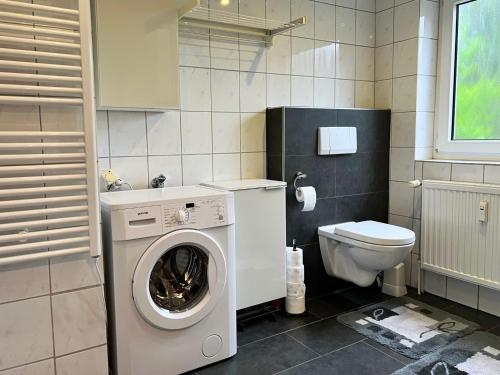 a bathroom with a washing machine and a toilet at Komfortable Ferienwohnung mit Terrasse auf Fehmarn in Fehmarn