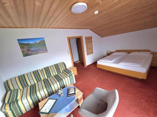 a living room with a bed and a couch at Pension Speckmoser in Bad Mitterndorf