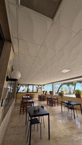a dining room with tables and chairs and windows at hotel cri cri - fronte spiaggia in Silvi Marina