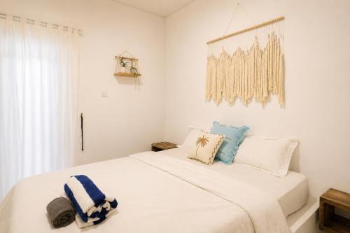 a white bedroom with a large white bed with pillows at Elia's House renovated in Canggu