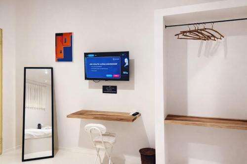 a bathroom with a tv on the wall and a mirror at Elia's House renovated in Canggu