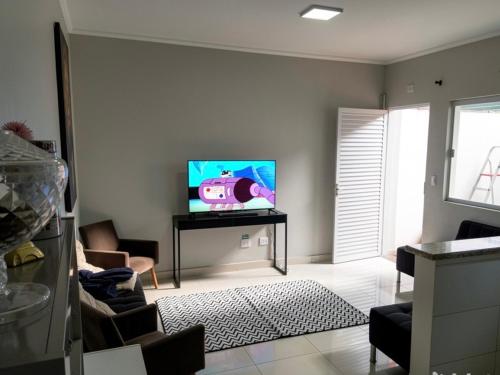 a living room with a flat screen tv on a wall at Casa aconchegante centro in Peruíbe