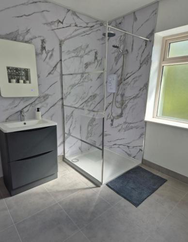 a bathroom with a shower and a sink at Waterfall Cottage in Killybegs
