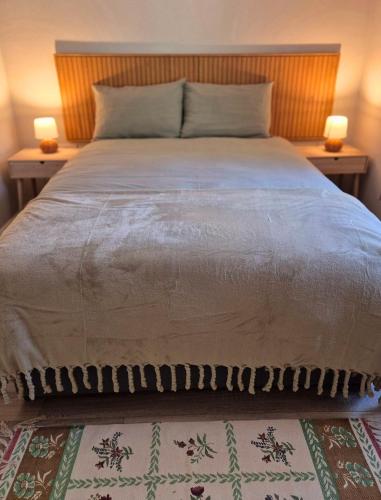 a large bed with two lamps on two tables at Waterfall Cottage in Killybegs