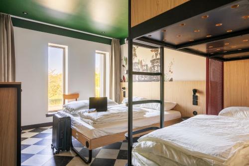 a bedroom with two bunk beds with a laptop on it at MEININGER Hotel Edinburgh Haymarket in Edinburgh