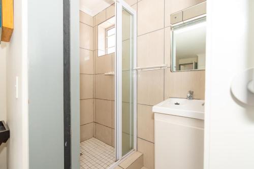 a bathroom with a shower and a toilet and a sink at Seabreeze Bungalow in Langebaan
