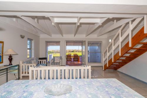 a room with a bed and a staircase at Seabreeze Bungalow in Langebaan