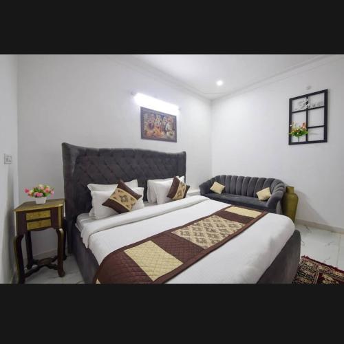 a bedroom with a large bed and a couch at The Udaikot farm in Rāma