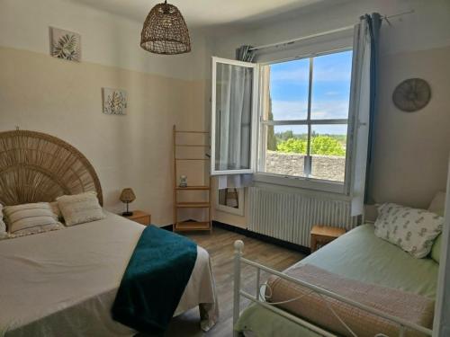 a bedroom with a bed and a window at Partie de villa in Velleron