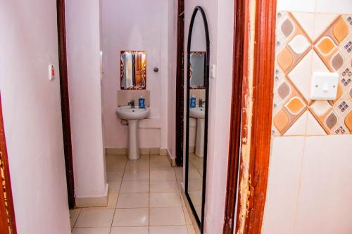 a bathroom with a sink and a mirror at Makenahluxuries Embu Paradise Apartment near Java Gakwegori in Kangaru