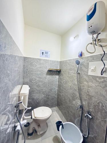a bathroom with a shower and a toilet and a sink at Wee Homes in Bangalore
