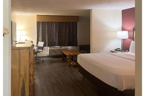 a hotel room with a bed and a desk at Studio 6 Suites Butte MT I-90 I-15 in Butte