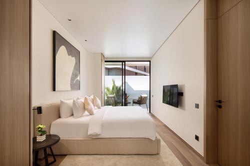 a bedroom with a large white bed and a window at Echo Beach Villas 6 in Canggu