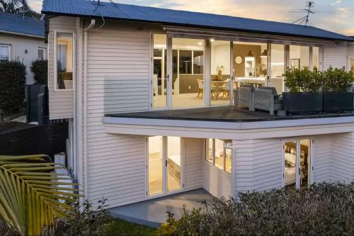 an extension of a house with a view of the patio at Ocean view Designer Standalone Villa Big Deck in Auckland