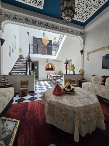 a living room with a table and a staircase at Riad Anbar in Marrakesh