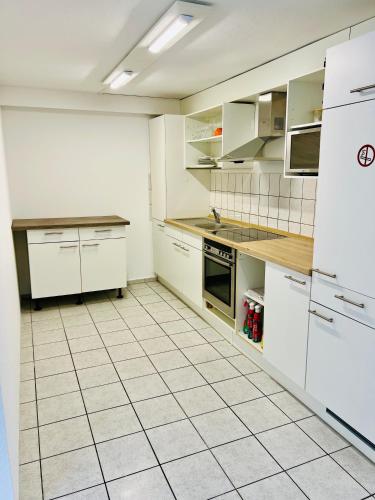 a kitchen with white appliances and a white tiled floor at Apartment mit 4 Betten in Karben
