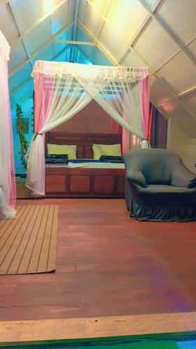 a bedroom with a bed and a canopy at Ella Kumi Wood Cabin in Ella