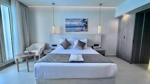 a bedroom with a bed and a table and a chair at Stella Beach Resort & Spa Makadi Bay - 24 HRS All Inclusive in Hurghada