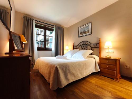 a bedroom with a bed and a window at AC Apartaments Incles in Incles