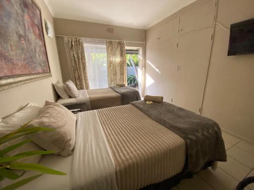 a bedroom with a bed and a couch and a window at Slaapnet Guesthouse Long Stay Accommodation Wilkoppies in Klerksdorp