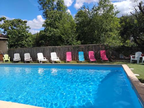 a group of chairs and a swimming pool at Hôtel La Gravenne in Thueyts