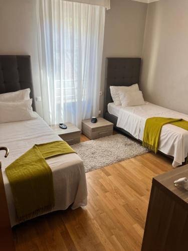 a bedroom with two beds with yellow blankets at Pine Resort by Residence in Strožanac