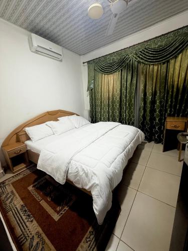 a bedroom with a large bed and a window at O Ansah Plaza Lodge in Kumasi