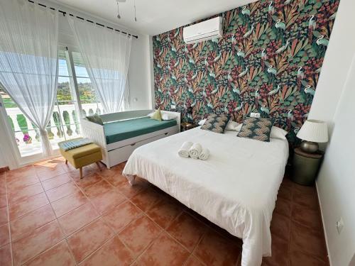 a bedroom with a bed with two white towels on it at Villa El Dorado in Estepona