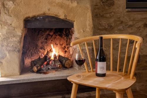 a bottle of wine sitting on a chair next to a fireplace at Rocha Suites in Rocca Cilento