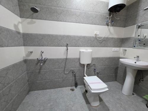 a bathroom with a toilet and a sink at Nirvana Stay & Gaming Zone in Bhadarwāh
