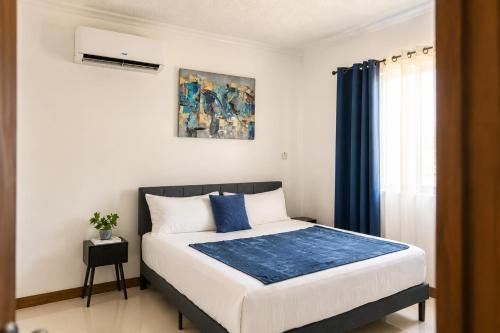 a bedroom with a large bed with blue curtains at The Nook in Kingston