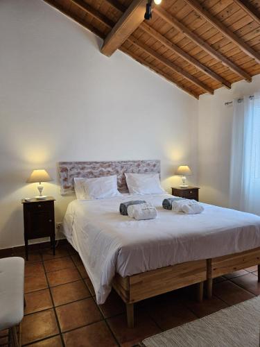 a bedroom with a large white bed with two lamps at Casa da Uva-Mosteiros Vineyards House-Heated swimming-pool in Mosteiros