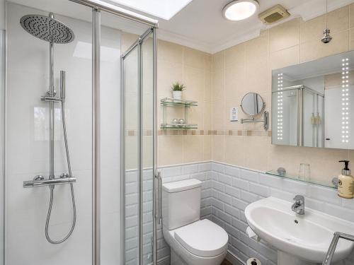 a bathroom with a shower and a toilet and a sink at Riviera Lodge Hotel in Torquay
