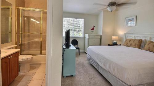 a bedroom with a bed and a television and a bathroom at 411 Mariners Club in Key Largo