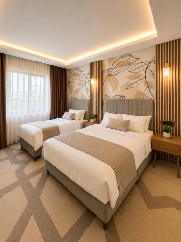 a hotel room with two beds in a room at Lumiera Suites Hotel in Nilüfer