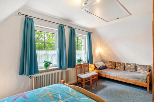 a bedroom with a bed and a couch and a window at An't Fischerspad in Wangerland