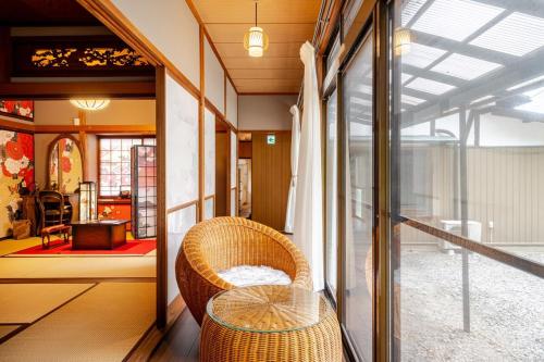 a room with a rattan chair and a table at 鸛雀庵Kanjyaku-an in Nakatsugawa