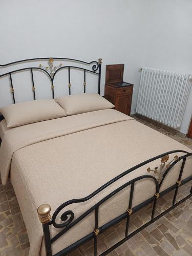 a bedroom with a bed with a metal frame at A casa di Nonna in Gambassi Terme