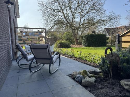 a pair of chairs sitting on a patio at Kustgeluk-Luxe aan Zee, splinternieuw appartement in het hart van Koudekerke in Koudekerke