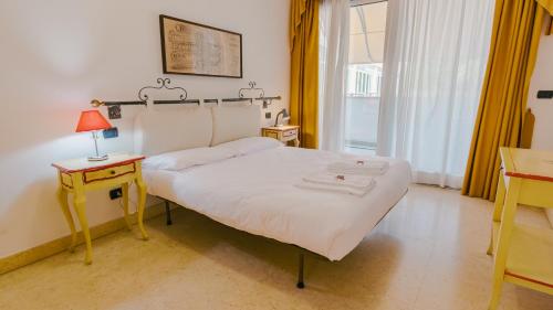 a bedroom with a bed and a table and a window at Residence Relais du Lac Village & Elite in Desenzano del Garda