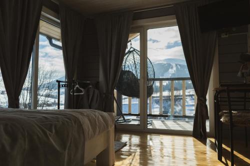 a bedroom with a bed and a view of a balcony at Tri houses in Podobovets