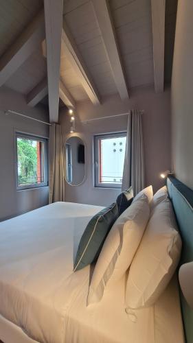 a large bed in a room with two windows at Michelangelo House, your personal Studio in Mestre