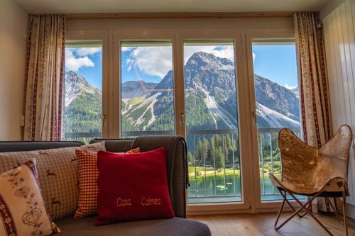 a living room with a couch and a large window at Casa Calmea in Arosa