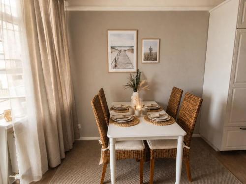 a dining room table with a white table and chairs at MareTime - inkl Wäschepakete, 50m zum Strand in Pelzerhaken