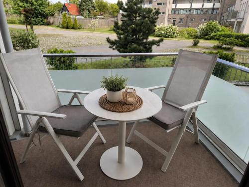 two chairs and a table on a balcony at MareTime - inkl Wäschepakete, 50m zum Strand in Pelzerhaken
