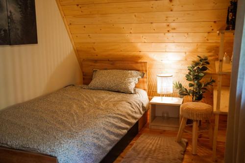 a bedroom with a bed and a table with a lamp at Planinska kuća Vista in Mrkopalj