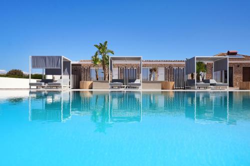 a swimming pool with blue water in front of a building at Cape Serenity Mansion in Ayia Napa