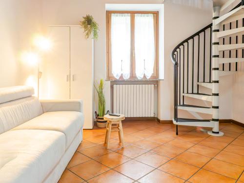 a living room with a couch and a staircase at White Nest - Lake Como & Ski Area in Ballabio