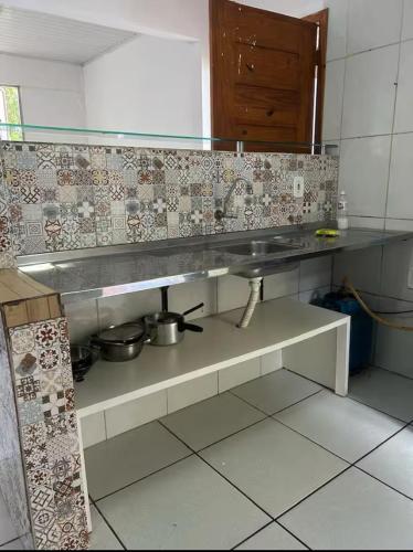 a kitchen with a counter with pots and pans at Lar sossego Itabuna in Itabuna